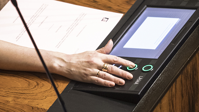 Täysistuntosalin permannolta otettu kuva, jossa kansanedustajat ovat poistumassa istuntosalista