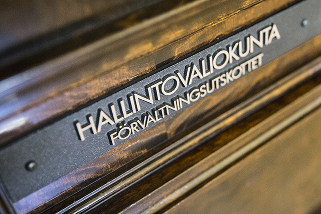 tummapuisessa ovessa kyltti jossa lukee hallintovaliokunta