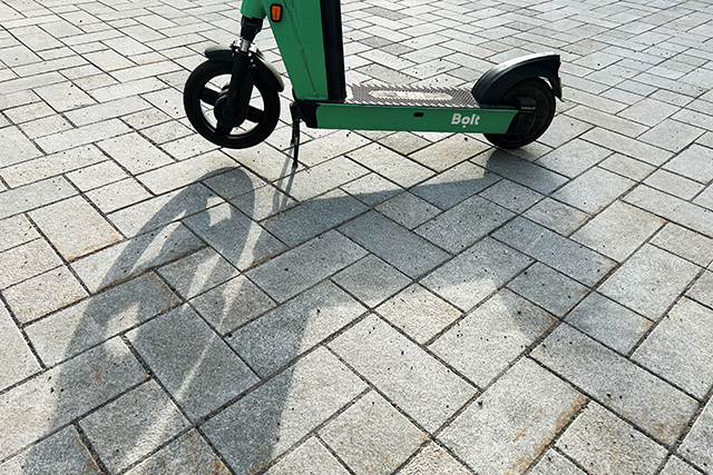 Vuokrattava sähköpotkulauta katukiveyksellä