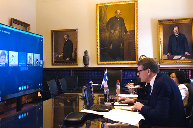 Speaker Vanhanen sitting in front of screen by speaker council meeting table