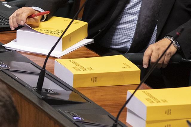 Talousarvioesityksiä eduskunnan täysistuntosalin pöydillä 