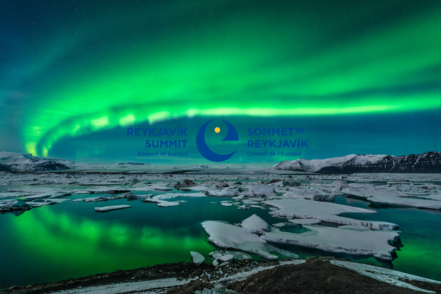Revontuloa sulan meren ja lumisten vuorien yllä. Kuvan päällä tekstinä Reykjavik Summit ja kokouksen logo.