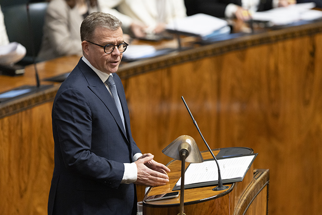 Pääministeri Petteri Orpo eduskunnan täysistuntosalin puhujakorokkeella puhumassa.