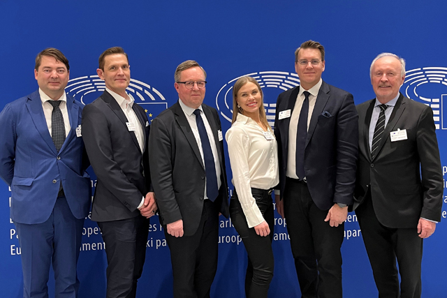 Kuvassa kuusi kansanedustajaa sinisen taustan edessä.